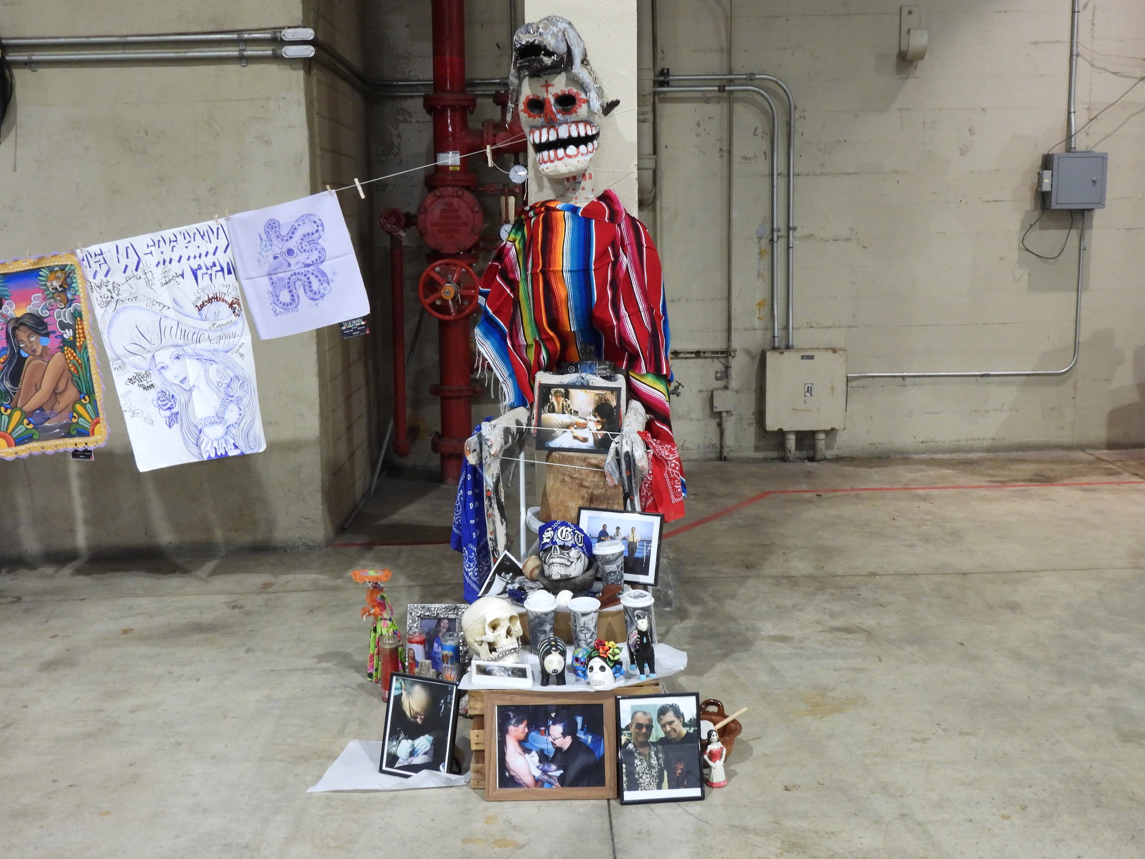 THE DEAD STILL GET THE LAST WORD A skeleton in a colorful striped outfit above family photographs and keepsakes in a Day of the Dead display