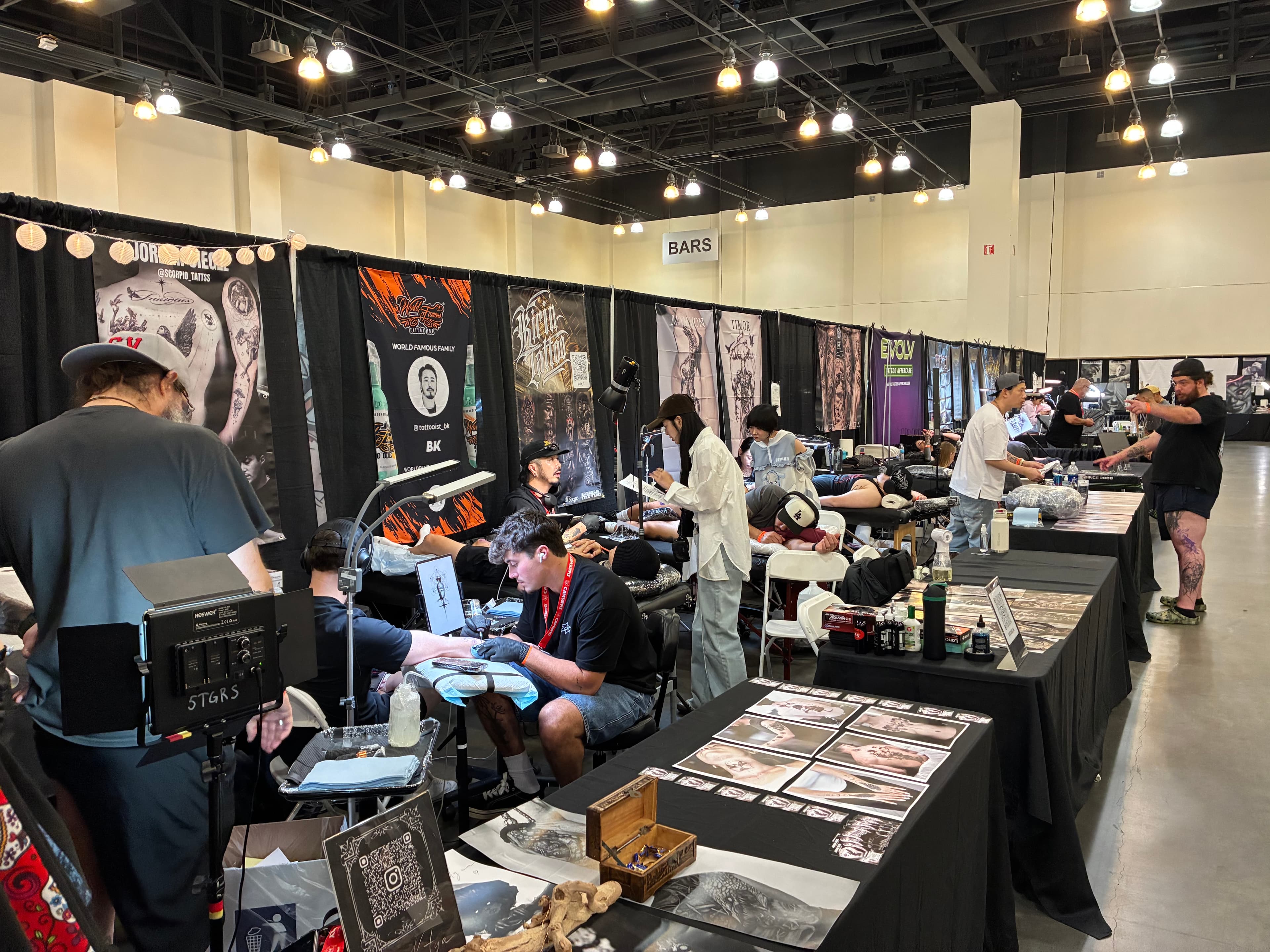 The Guy Ten Feet Away Does the Same Thing You Do Tattoo artists working in neighboring booths along a crowded convention aisle